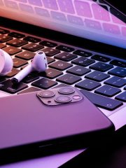 Image of Apple products, an iPhone, a macbook, and Airpods.