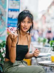 Woman looks confused with glasses in her hands... background is blurred